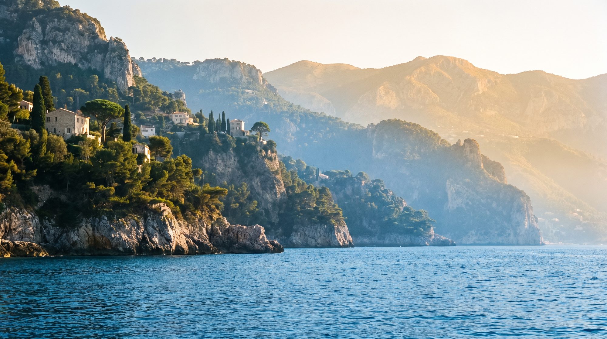Limestone headlands of the French Riviera receding into golden haze