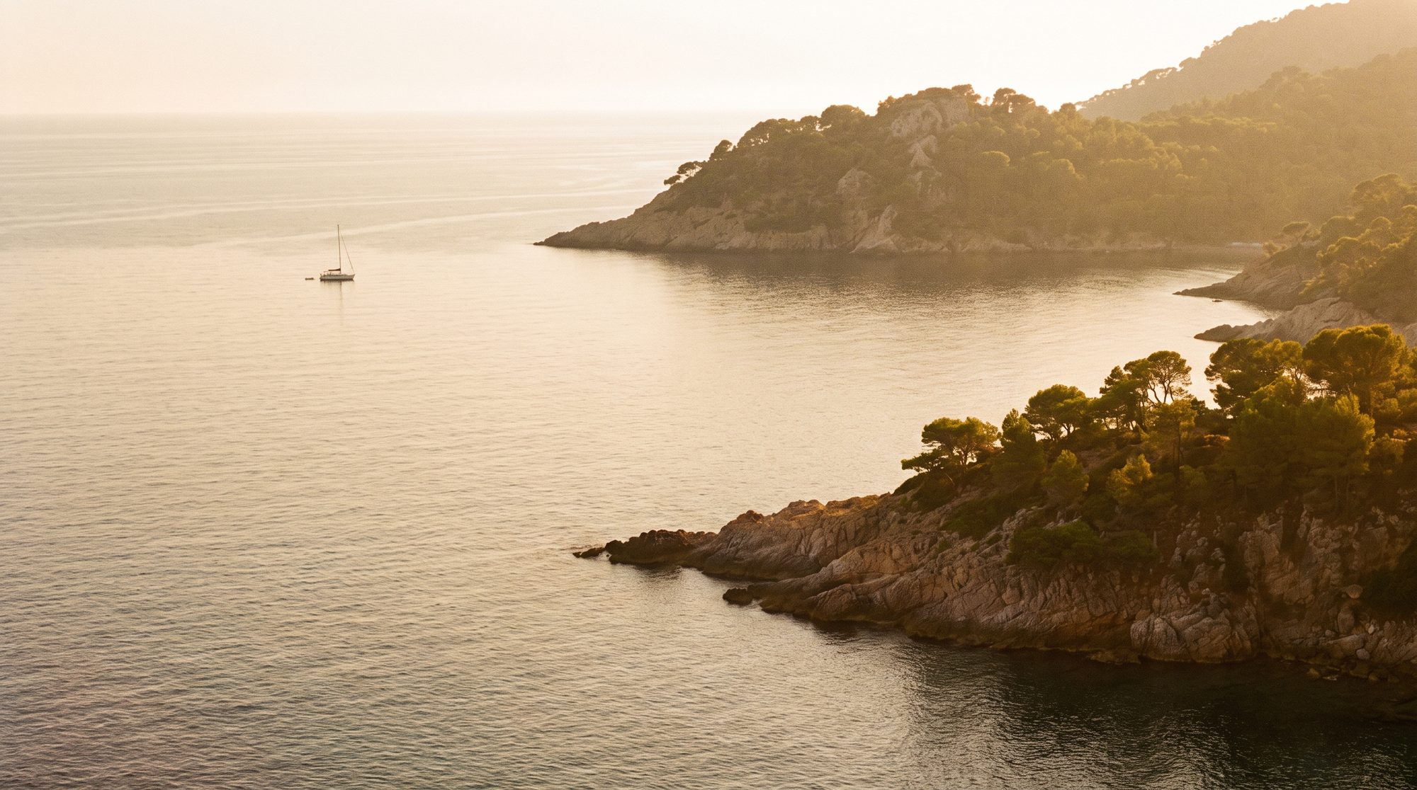 September's glassy golden sea, one sail on the horizon