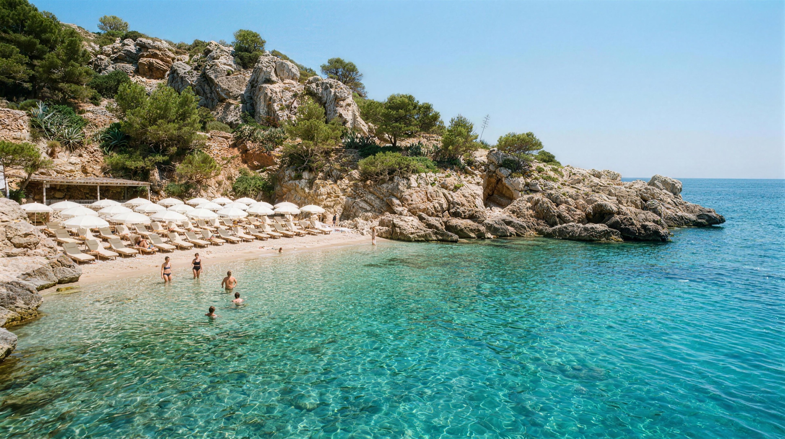 A beach club in a turquoise cove beneath the cliffs between Nice and Monaco